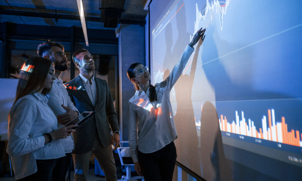 Team reviewing AI analytics and data visualization on digital screen for strategic decision-making