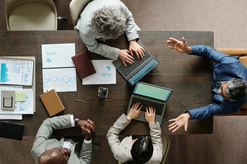 Executive leadership team collaborating during a strategic planning meeting to discuss corporate communications, business strategy, and executive decision-making.